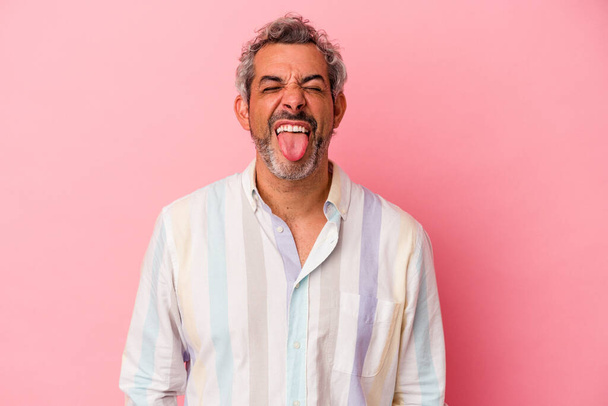 Middle age caucasian man isolated on pink background  funny and friendly sticking out tongue. - Photo, Image