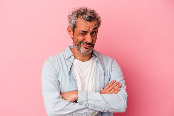 Middle age caucasian man isolated on pink background  suspicious, uncertain, examining you. - Fotoğraf, Görsel