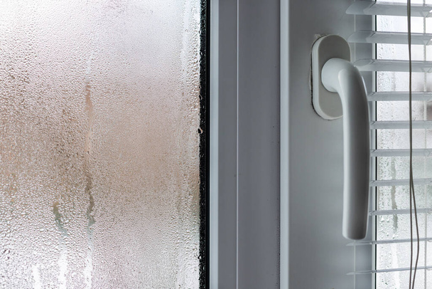 Szyba okna z kondensacją, naturalne krople wody na szkle, wysoka wilgotność. - Zdjęcie, obraz