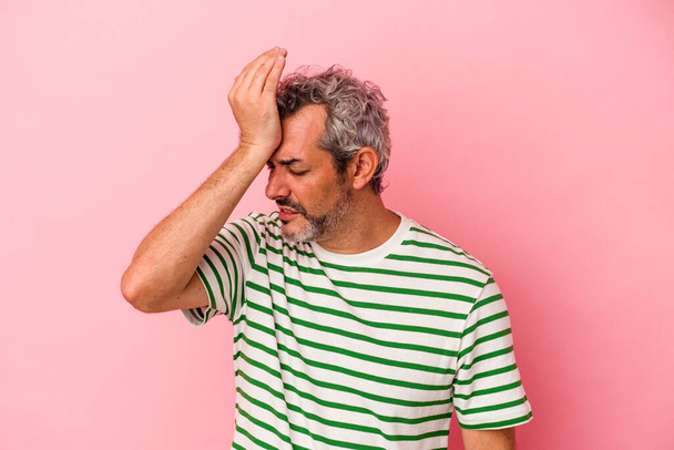 Middle age caucasian man isolated on pink background  forgetting something, slapping forehead with palm and closing eyes. - Foto, imagen