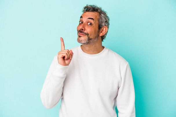 Middle age caucasian man isolated on blue background  showing number one with finger. - Photo, Image