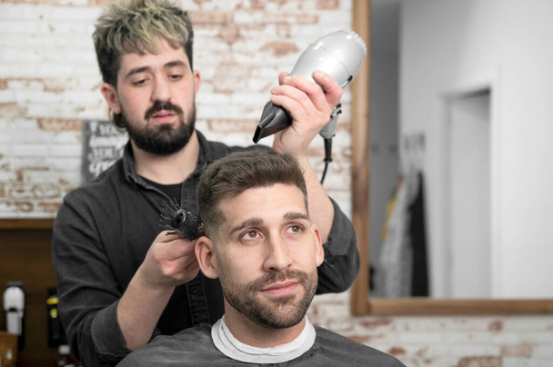 Barber drying hair of customer - Photo, Image