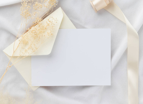 Convite de cartão de saudação em branco Mockup 5x7 no envelope com flores secas e fita no fundo de papel, flat lay, mockup - Foto, Imagem