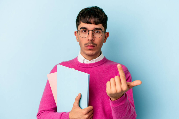 Young mixed race student man isolated on blue background pointing with finger at you as if inviting come closer. - Foto, imagen