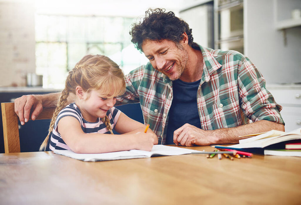 È importante fornire incoraggiamento ai bambini. Colpo ritagliato di un padre che aiuta sua figlia con i compiti. - Foto, immagini