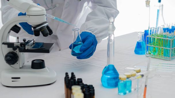 chemistry experiment and test tube in hand in science class on table Scientist education concept with glass flask in laboratory research and development concept - Photo, Image
