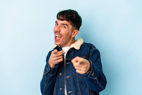 Young mixed race man isolated on blue background cheerful smiles pointing to front. - Photo, Image