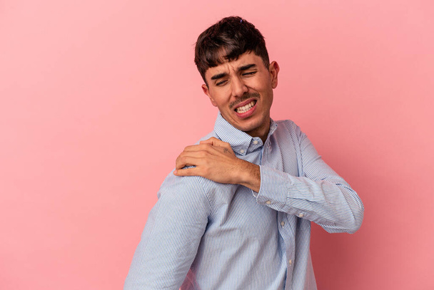Junger Mann mit gemischter Rasse isoliert auf rosa Hintergrund mit Schulterschmerzen. - Foto, Bild