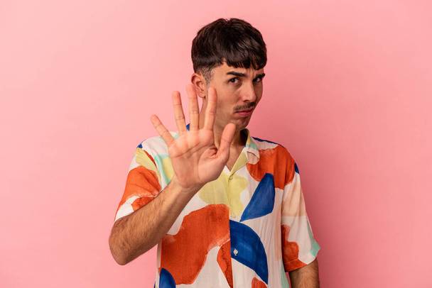 Young mixed race man isolated on pink background rejecting someone showing a gesture of disgust. - Photo, Image