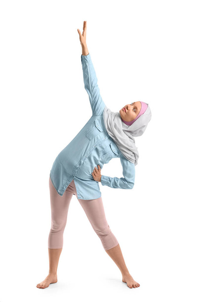 Schwangere Muslimin macht Yoga auf weißem Hintergrund - Foto, Bild