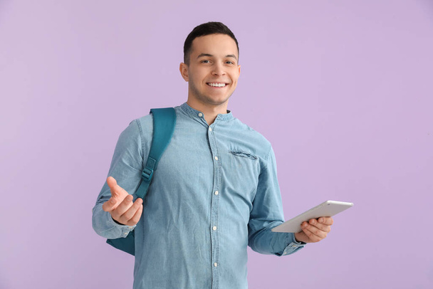 mężczyzna student z tablet komputer na tle liliowym - Zdjęcie, obraz