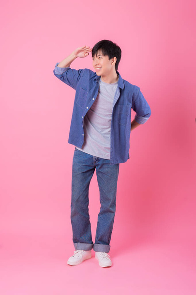 Jeune homme asiatique posant sur fond rose - Photo, image