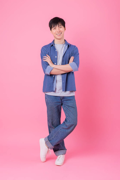 Young Asian man posing on pink background - Foto, afbeelding