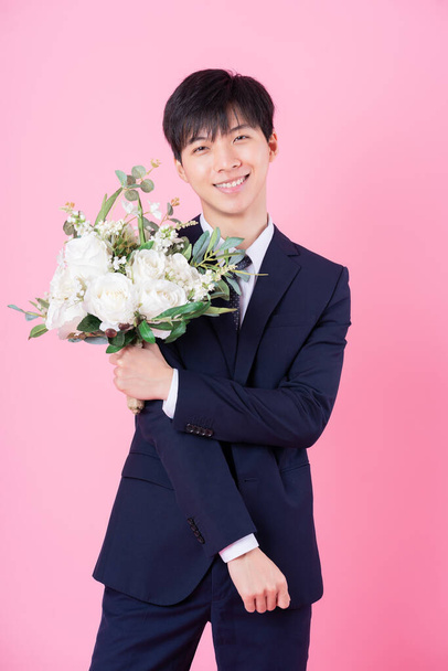 Junge asiatische Bräutigam posiert auf rosa Hintergrund - Foto, Bild