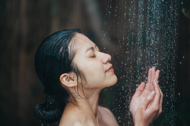Gyönyörű fiatal ázsiai nő pihentető zuhanyozás közben - Fotó, kép