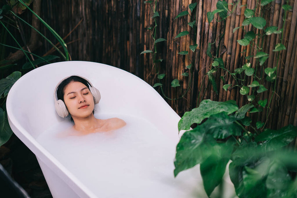 mooie jonge aziatische vrouw ontspannen in het bad - Foto, afbeelding