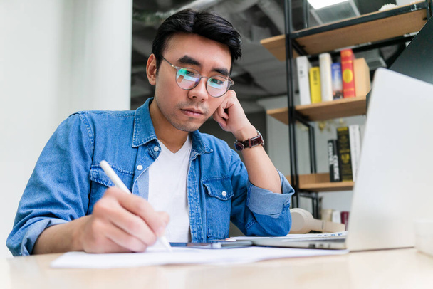Fiatal ázsiai férfi dolgozik az irodában - Fotó, kép