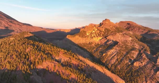 Aerial panoramic dramatic view of a wilderness mountain peak and a road forest rocky volcanic landscape in the clouds at golden hour sunset in Tenerife, Spain, Europe. - Footage, Video
