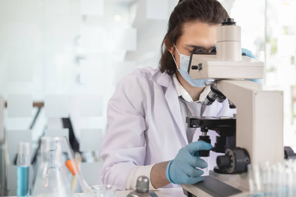 Vědci nebo výzkumníci provádějí mikroskopickou endoskopii, aby zkoumali změny v chemických reakcích a degradaci buněk, laboratorní experimenty, výzkumní pracovníci vědecká pracovní analýza pomocí zkumavky. - Fotografie, Obrázek