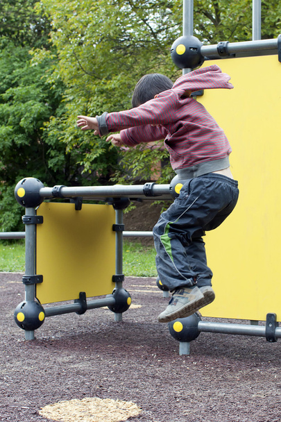 Child jumping at playground - Фото, изображение