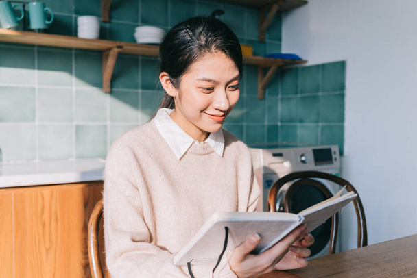 молода азіатська жінка читає книгу вдома
 - Фото, зображення