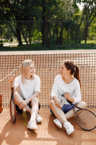 Female friends having a rest after tennis game - Foto, afbeelding