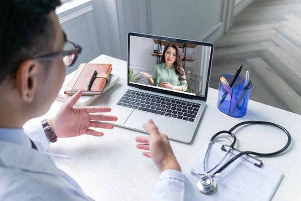 I medici asiatici sono telemedicina per i pazienti tramite videocall, concetto di telesalute - Foto, immagini
