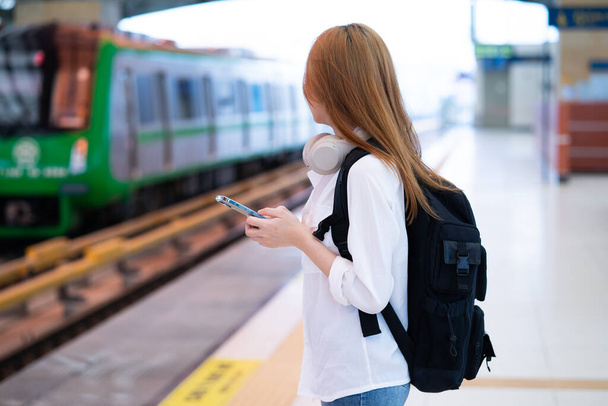 Mladá asijská dívka čeká na vlak na nádraží - Fotografie, Obrázek