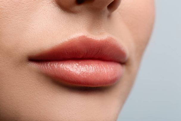 Closeup view of woman with beautiful lips on light background - Zdjęcie, obraz