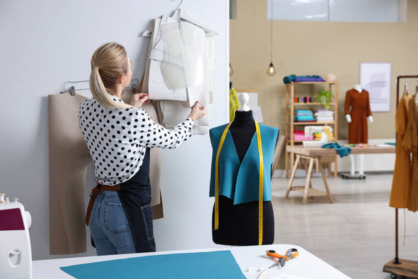 Dressmaker working in modern atelier, back view - Foto, afbeelding