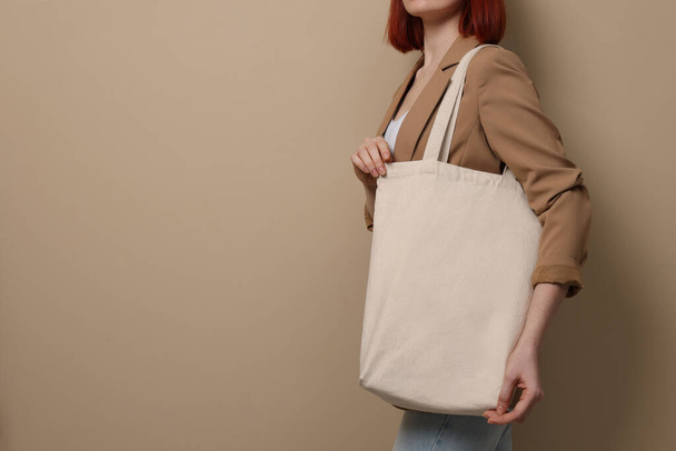 Woman with eco bag on beige background, closeup. Space for text - Foto, afbeelding