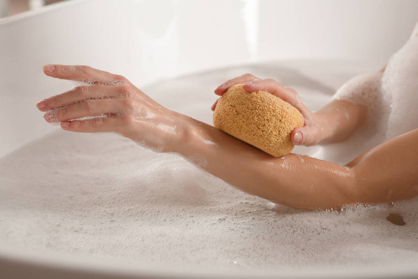 Woman rubbing her forearm with sponge while taking bath, closeup - Φωτογραφία, εικόνα