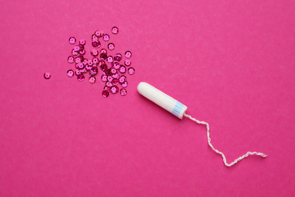 Tampon and sequins on pink background, flat lay. Menstrual hygiene product - Fotoğraf, Görsel