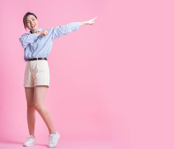 Imagem de comprimento total da jovem mulher asiática posando no fundo rosa - Foto, Imagem
