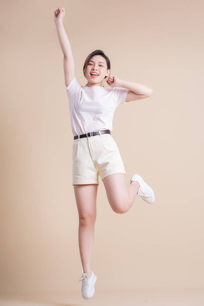 Full length image of young Asian woman posing on background - Photo, Image