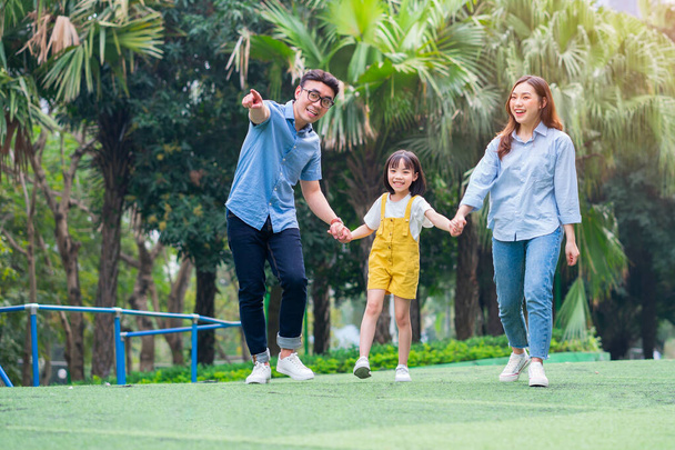 Képek fiatal ázsiai családokról, akik együtt játszanak a parkban - Fotó, kép