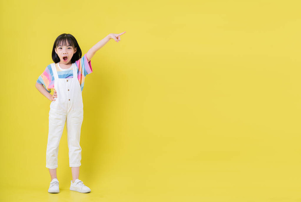 Full length image of Asian child posing on yellow background - 写真・画像