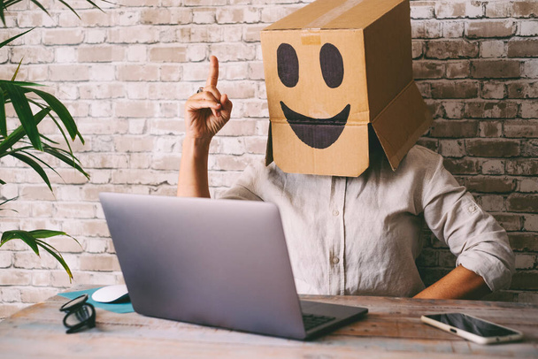 Happy and successful people working on computer wearing smile box on head. Joyful online digital anonymous worker on laptop in video call. Good news on web internet communication leisure - Fotoğraf, Görsel