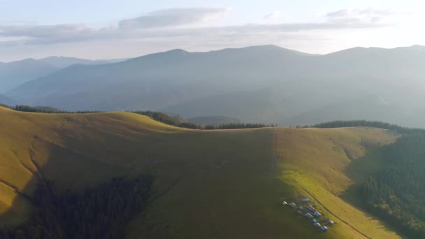 Do olho de um pássaro vista assentamento de montanha alpina nas colinas verdes. Filmado em vídeo UHD 4k. - Filmagem, Vídeo