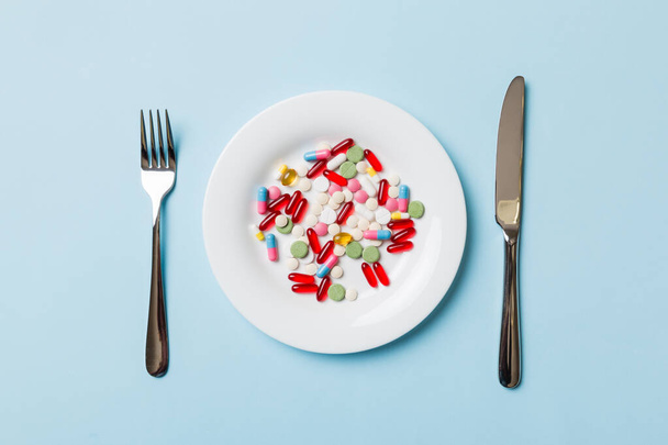 Many different weight loss pills and supplements as food on round plate. Pills served as a healthy meal. Drugs, pharmacy, medicine or medical healthycare concept. - Foto, immagini