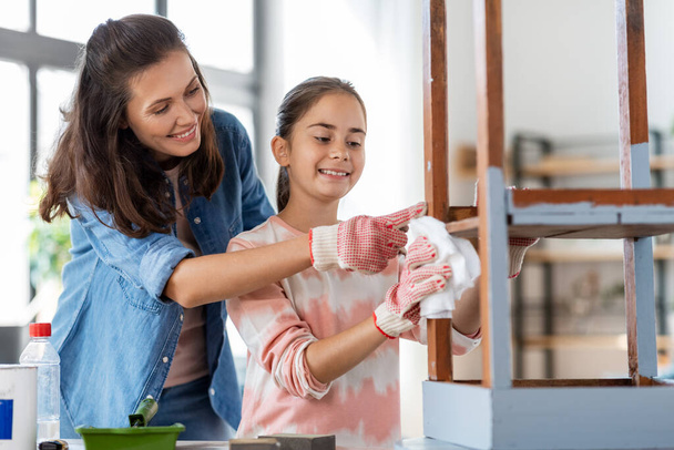 mother and daughter cleaning old table with tissue - Foto, Bild