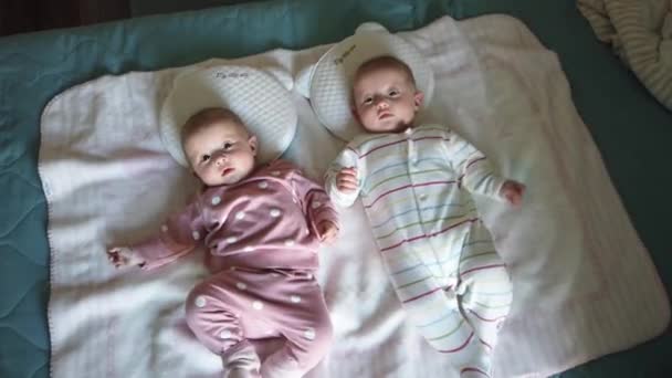 Deux filles soeurs allongées sur le lit. Deux bébés jumeaux sur le lit - Séquence, vidéo