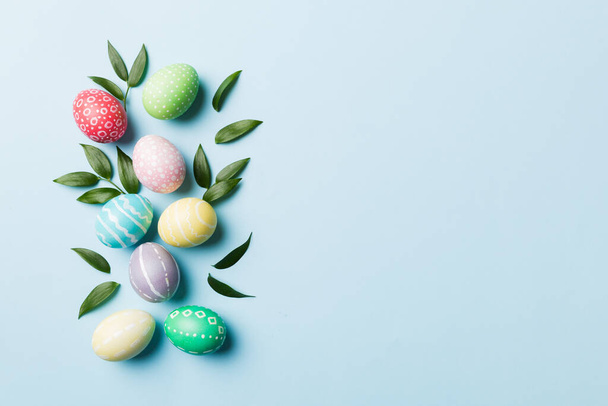 Huevos de Pascua coloridos con hojas de flores de primavera aisladas sobre fondo blanco. Huevo de color Frontera de vacaciones. - Foto, Imagen