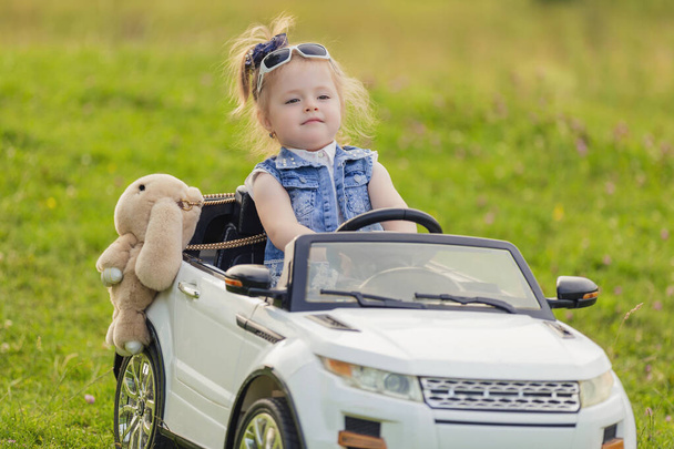 little girl rides in a childrens car - Foto, imagen