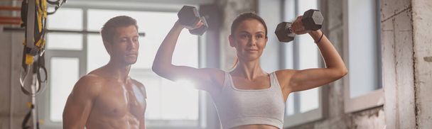 Athletic woman is actively exercising in the fitness club - 写真・画像