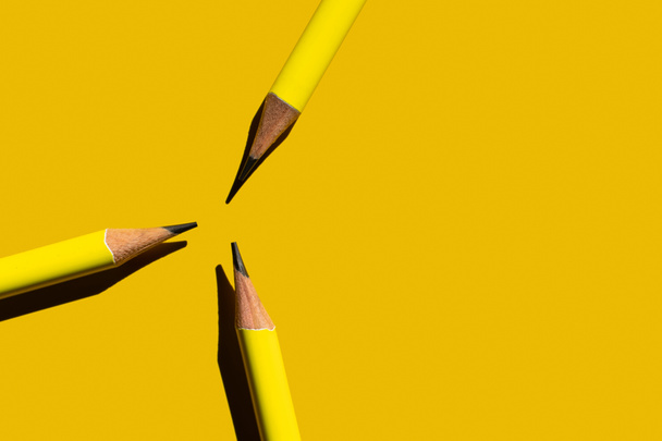 επίπεδη θέσει με αιχμηρά μολύβια σε κίτρινο φόντο  - Φωτογραφία, εικόνα