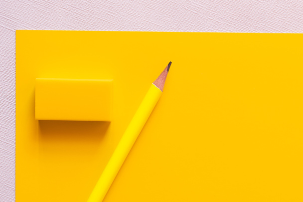 top view of pencil near eraser on yellow and white - Foto, afbeelding