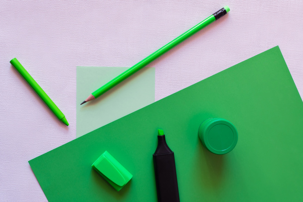 vue du dessus du crayon, du crayon, du pot avec de la peinture et du stylo marqueur sur vert et tout en - Photo, image
