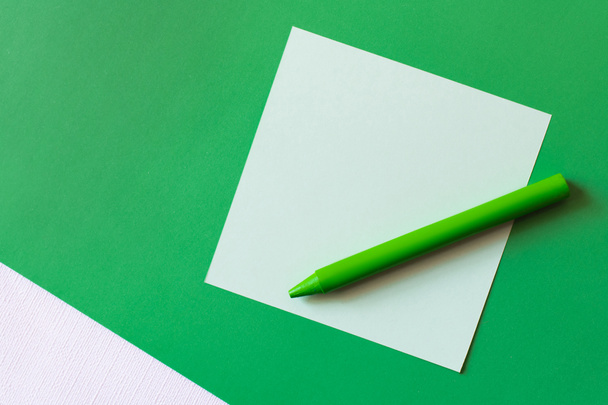 top view of crayon near paper note on green - 写真・画像