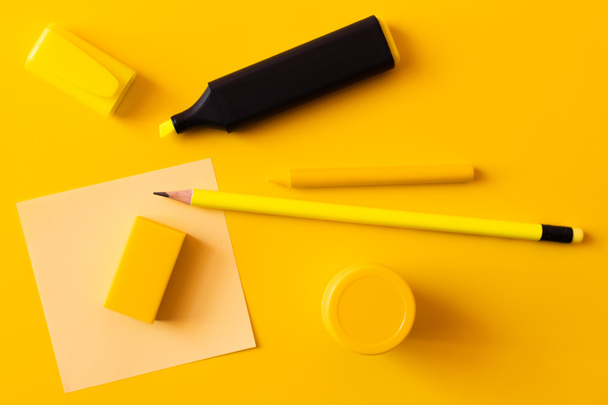 top view of stationery and marker pen near paper note on yellow - 写真・画像